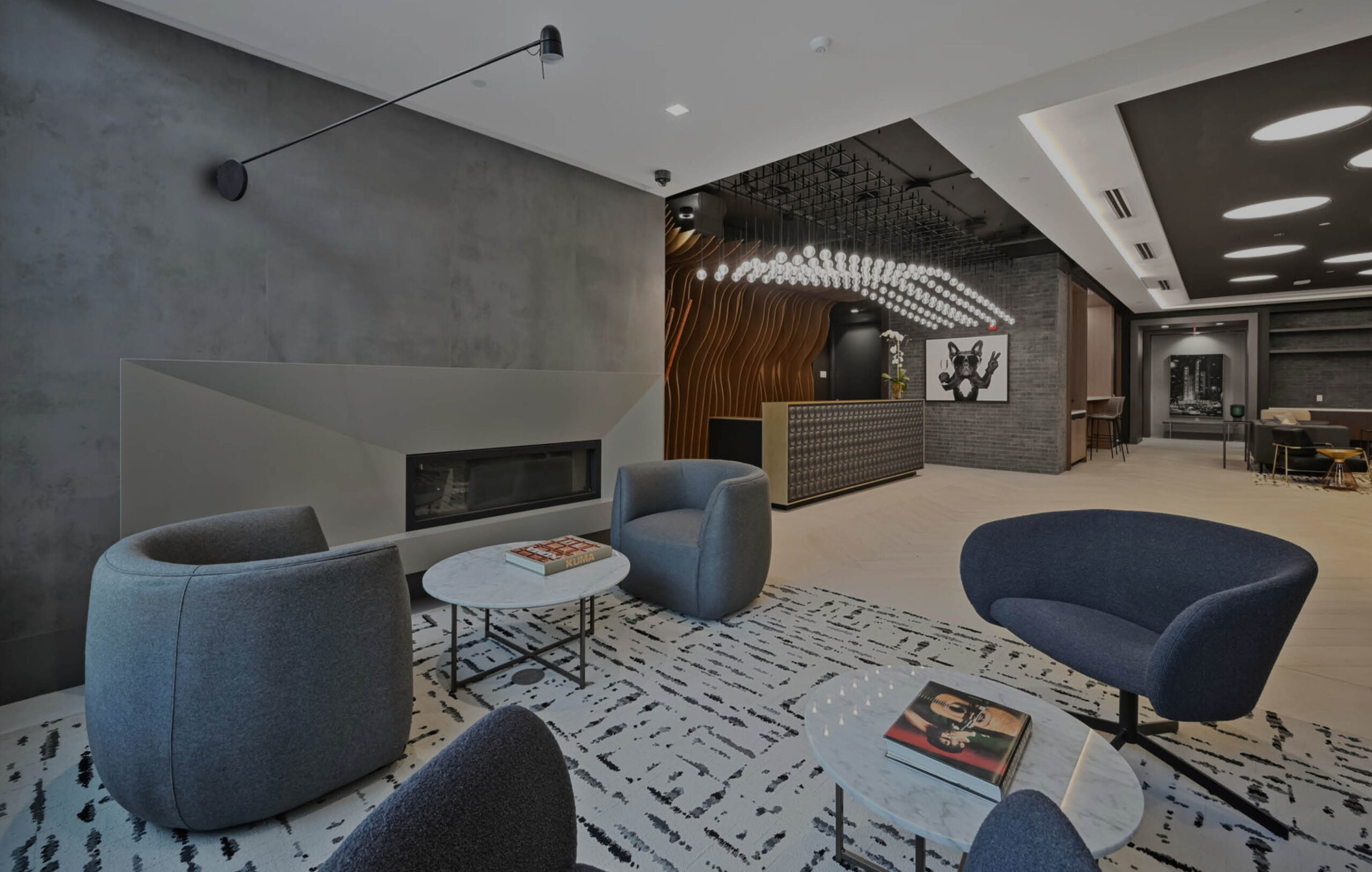 Mount Vernon Triangle, Washington, DC, High-Rise Apartments Near Georgetown University Law Center - Claret - Lobby Area With Reception Desk, Light-Colored Tiles, Pendant Lighting, Wavy Feature Wall.