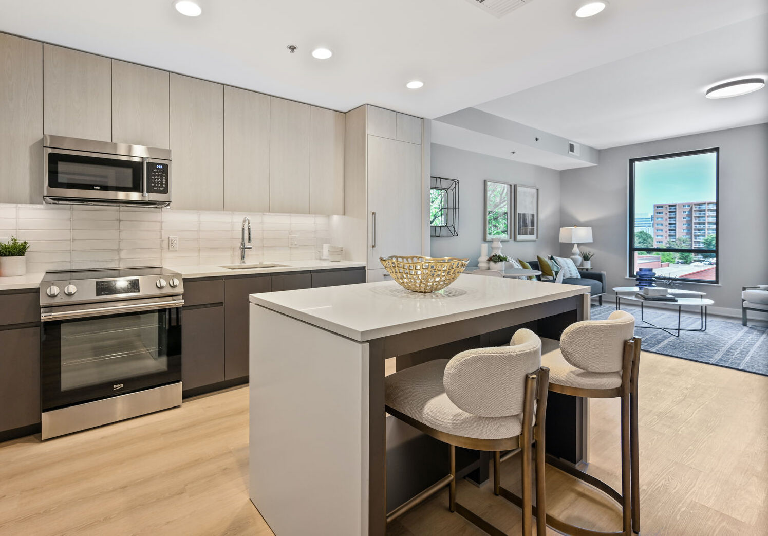 Mount Vernon Triangle, Washington, DC, Luxury Apartments Near Safeway - Claret - Living Room With Luxury Plank Flooring, Couch, Armchair, Round Coffee Table, Side Table, Lamps, And Large Windows.