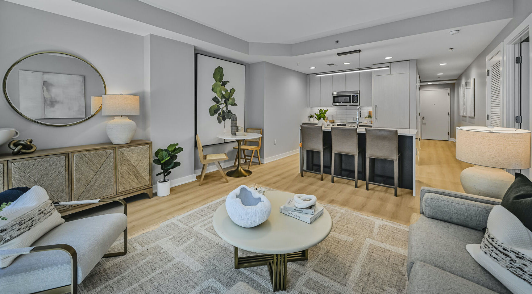 Mount Vernon Triangle, Washington, DC, Luxury Apartments Near Safeway - Claret - Living Room With Luxury Plank Flooring, Couch, Armchair, Round Coffee Table, Side Table, Lamps, And Large Windows.